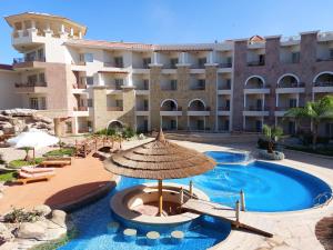 赫尔格达Royal Beach Private Apartments Hurghada的大型酒店,设有遮阳伞和游泳池