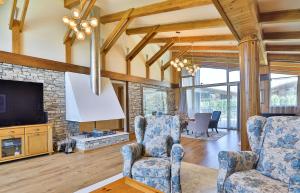 班斯科Luxury Chalets Pirin Golf & Country Club的客厅配有两把椅子和电视