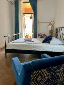 第比利斯Guest House Third Floor的一间卧室配有一张床和一张蓝色椅子