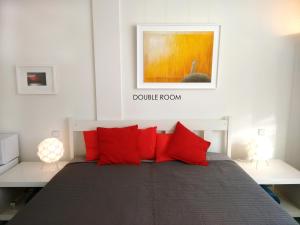 不莱梅洛夫特76号公寓的一间卧室配有红色枕头的床