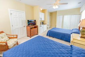 默特尔比奇Grande Villas at World Tour Golf Resort的一间卧室配有2张蓝色的床和电视