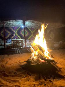 MhamidMhamid Sahara Golden Dunes Camp - Chant Du Sable的夜间建筑物前的火坑