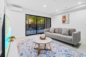 悉尼Urban Oasis in Heart of Homebush的客厅配有沙发和桌子