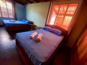福尔图纳Casa Nativo Spring Arenal的客房内的两张床和毛巾