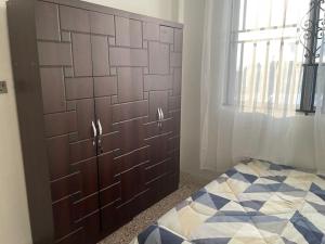 库马西Bright & Beautiful 2-Bed Apartment, Central Kumasi的一间卧室配有木制床头板和一张床