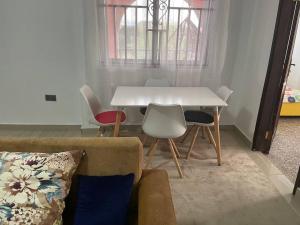 库马西Bright & Beautiful 2-Bed Apartment, Central Kumasi的客厅配有白色的桌子和椅子