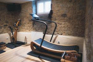 里摩日Villa37 - Maison privée indépendante centre-ville Limoges的一个带跑步机的健身房,位于一个石墙房间内