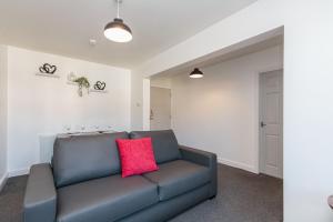 布莱克浦Cherry Property - Cranberry Suite的客厅配有蓝色沙发及红色枕头