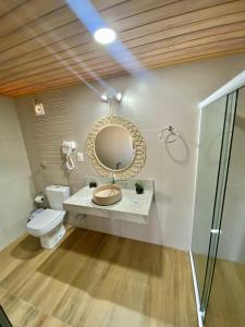 雅帕拉廷加Pousada Yapara-Tyba的浴室设有卫生间和墙上的镜子。