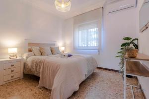 蓬塔翁布里亚Chalet a pie de playa的白色的卧室设有床和窗户