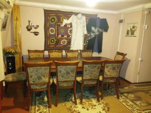杜尚别Sayfi Guesthouse的餐桌,椅子和挂在墙上的连衣裙