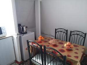 杜尚别Sayfi Guesthouse的一张桌子、两把椅子和一张桌子,上面有水果