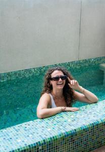 埃斯孔迪多港Madre Tierra Hotel & Coworking & Hostal的戴太阳镜的游泳池里的女人
