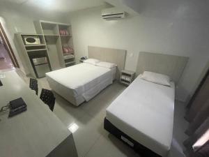 巴西利亚MIX APART Hotel的酒店客房设有两张床和一张桌子。