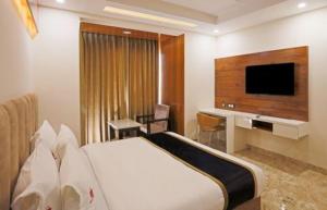 新德里HOTEL Seven Heaven -Lawrence Road New Delhi的配有一张床和一台平面电视的酒店客房