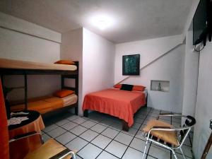 萨利纳斯Hotel Cocos的客房设有两张双层床和一张桌子及椅子。