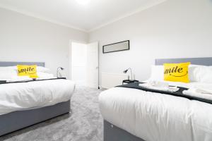 艾尔德里Bell Apartment的卧室内的两张床,配有白色和黄色枕头