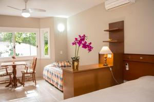 卡内拉Hotel Cozumel Sierra的一间卧室配有一张床和一张花瓶桌子