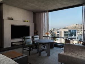 雅典Monastik Living in Athina的客厅配有电视和桌椅