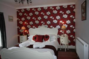 皮克林High Dalby House的一间卧室,配有红色和白色的鲜花