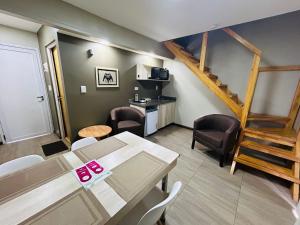 伊瓜苏港Ingá Apart & Suites的一间带桌椅和楼梯的客厅