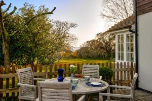 彼得斯菲尔德Garden flat near Goodwood with stunning views的庭院设有围栏,配有桌椅