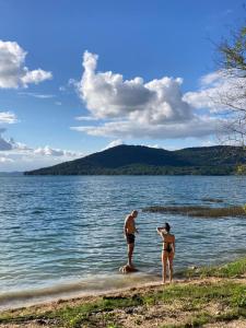 埃尔莱马特Bikini Beach的两个人站在湖岸边