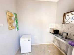 KibweniMama's House的厨房配有白色冰箱和台面