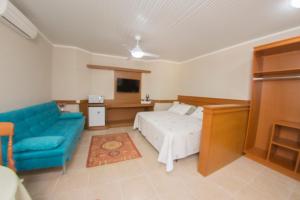 卡内拉Hotel Cozumel Sierra的一间卧室配有一张床和一张蓝色的沙发