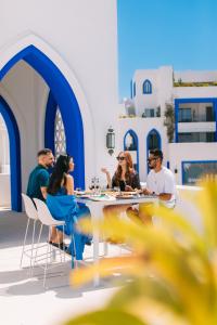亚喀巴Cloud 7 Residences Ayla Aqaba的一群坐在餐厅桌子上的人