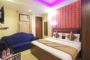 新德里HOTEL Seven Heaven -Lawrence Road New Delhi的一间卧室配有一张床和一张蓝色的沙发