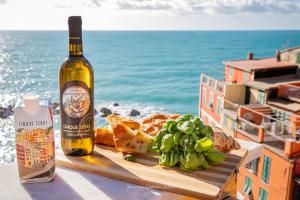 里奥马哲雷阿拉玛琳娜民宿的一瓶葡萄酒和一盘食物在海边