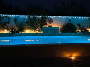 圣雷米普罗旺斯Les Logis de Cocagne的游泳池在晚上点亮,灯光照亮