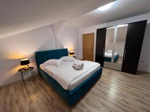 锡比乌Helix Apartaments的一间卧室配有蓝色的床和镜子