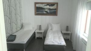 BillnäsMetsäniityn Tuvat的卧室配有两张床,墙上挂着一幅画