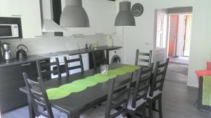 BillnäsMetsäniityn Tuvat的一间带黑色桌椅的厨房和一间带炉灶的厨房