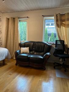 泰比Stockholm-Arlanda privat rum i rymlig villa gratis wifi 1Gb fiber parkering Room1的客厅设有真皮沙发,配有窗户