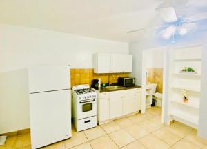 哈兰代尔海滩Hallandale Beach Motel的厨房配有炉灶和白色冰箱。
