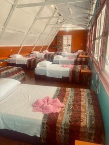 利文斯顿Hotel La Casa Rosada的一组床,一排在房间内