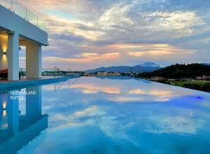 哥打京那巴鲁QUEENSLAND SUITES at Aru Suites, Kota Kinabalu的一座阴天大厦屋顶上的游泳池