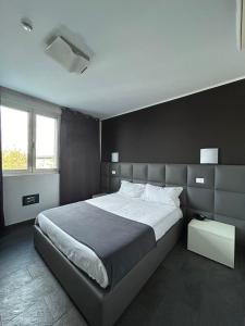 Noventa Vicentina诺文塔酒店的一间卧室设有一张大床和黑色墙壁