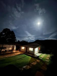 圣安娜杜里亚舒HOSTEL DA LAPINHA的天空中月亮的夜晚房屋