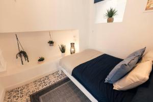 大莫尔文Cosy hillside cottage的卧室配有一张床,墙上挂着盆栽植物