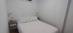 坎德拉里亚Calesapart2 Brisa Marina的卧室配有带枕头的白色床