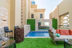 迪拜ELAN RIMAL SADAF Suites的后院设有游泳池和绿草