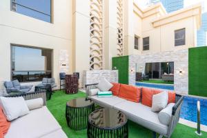 迪拜ELAN RIMAL SADAF Suites的一个带沙发和椅子的庭院和一个游泳池