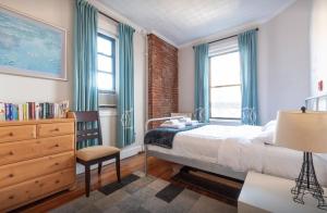 纽约Amazing 3 Bedroom Apartment的卧室配有床、椅子和窗户。