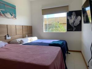 瓜拉久巴Guarajuba-Village de Alexandre. Praia e Piscina!的一间卧室设有两张床和窗户。