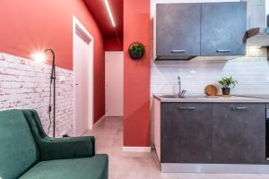 博洛尼亚Tartini Lofts的一间带红色墙壁和绿色沙发的厨房