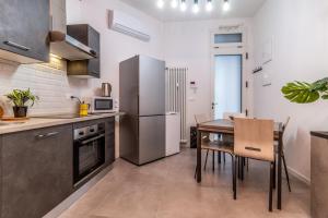 博洛尼亚Tartini Lofts的厨房配有桌子和不锈钢冰箱。